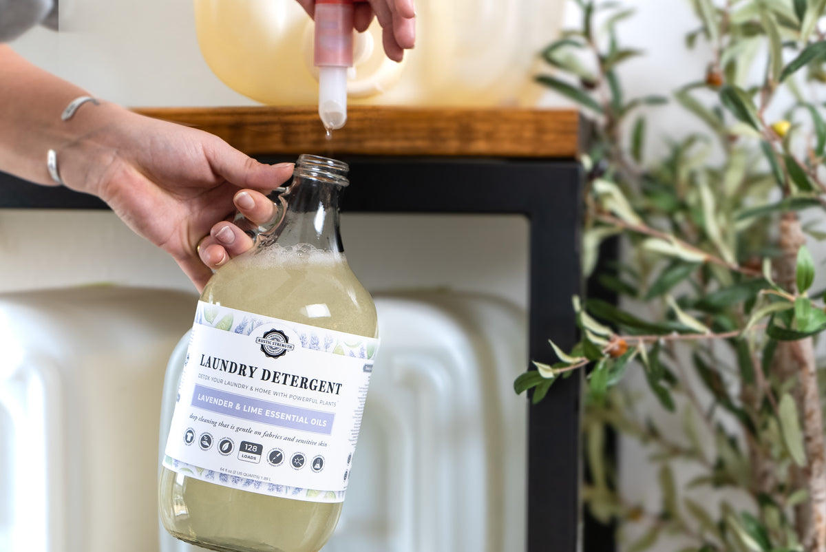Rustic Strength, photoshoot image of a glass jug being filled from an eco-jug with spout